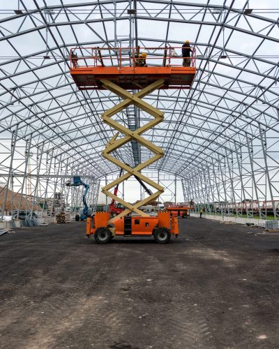 Lift with platform work in warehouse hangar construction field.